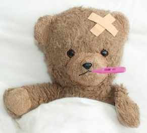 Teddy bear with a thermometer in it's mouth